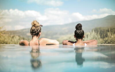 Two women looking out from an infinity pool