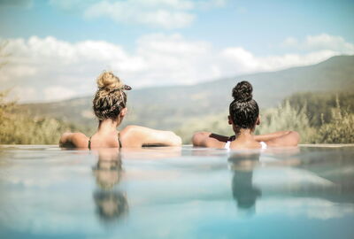 Two women looking out from an infinity pool