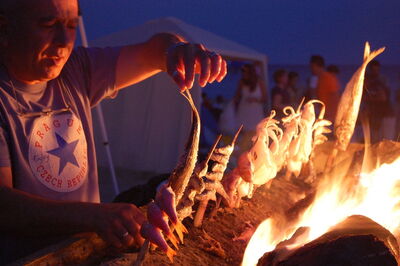 A man grilling fish on the beach