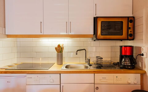 Les Huskies: Brown, Cabinetry, Kitchen Sink, Countertop, Property, Sink, Kitchen Appliance, Tap, Kitchen Stove, Kitchen