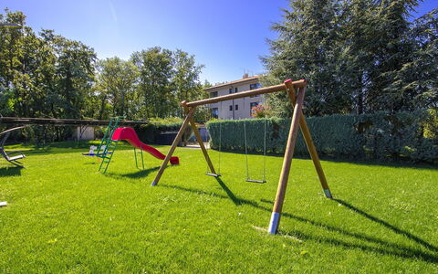 Oliva 1: Swing, Playground, Outdoor Play Equipment, Public Space, Grass, Sky, Human Settlement, Tree, Lawn, Land Lot
