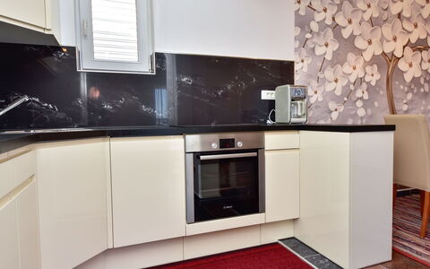 Fliri: Countertop, Cabinetry, Furniture, Kitchen, Wood, Kitchen Stove, Home Appliance, Lighting, Interior Design, Flooring