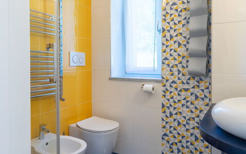 Di Sara: Bathroom, Yellow, Blue, Room, Property, Shower Curtain, Tile, Toilet, Interior Design, Bathroom Accessory