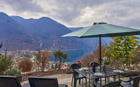 Porlezza 84: Sky, Cloud, Table, Property, Furniture, Umbrella, Plant, Water, Mountain, Shade