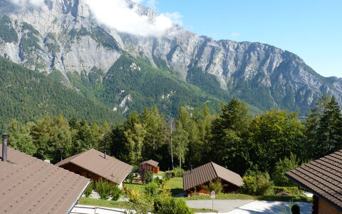 Ambigu: Sky, Mountain, Plant, Cloud, Ecoregion, Tree, Natural Landscape, Highland, House, Building