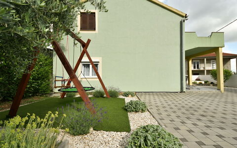 Laura: Plant, Cloud, Sky, Building, Land Lot, Road Surface, Tree, Grass, Residential Area, Neighbourhood
