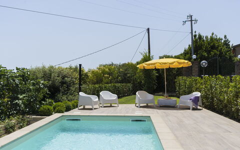 Villa Bougainvillea: Water, Plant, Property, Sky, Swimming Pool, Shade, Umbrella, Outdoor Furniture, Building, Grass