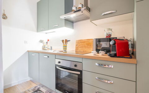 Atzeni: Countertop, Cabinetry, Building, Drawer, Kitchen Stove, Kitchen, Kitchen Appliance, Wood, Lighting, Interior Design