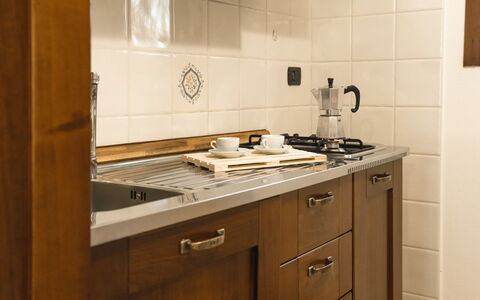 Violet Residence In Orosei: Kitchen, Countertop, Kitchen Appliance, Cabinetry, Wood, Flooring, Major Appliance, Interior Design, Stove, Kitchen Stove