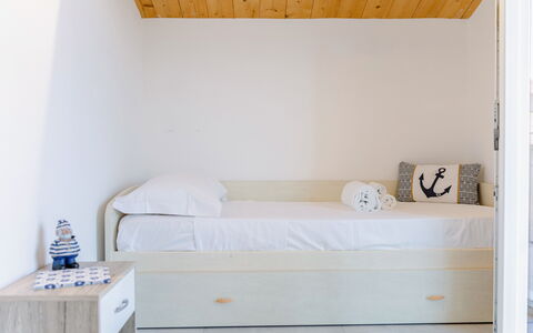 Seaside Apartment: Furniture, Bedroom, Wall, Interior Design, Floor, Bed, Wood, Flooring, Room, Linens