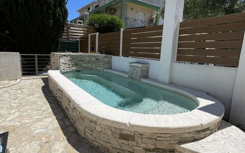 Volme: Composite Material, Swimming Pool, Flagstone, Water Feature, Outdoor Furniture, Concrete, Stone Wall, Tile, Shade, Cobblestone