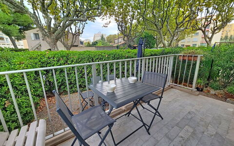 Les Floralies: Furniture, Outdoor Furniture, Table, Outdoor Table, Chair, Porch, Balcony, Kitchen & Dining Room Table, Shade, Fence