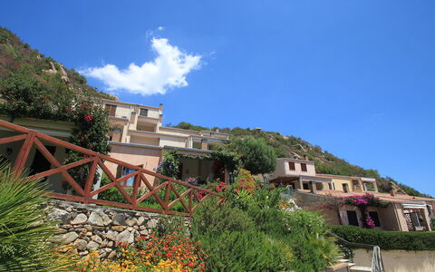 Costa Rei 100: Sky, Cloud, Plant, Property, Building, Azure, Vegetation, Mountain, Biome, House