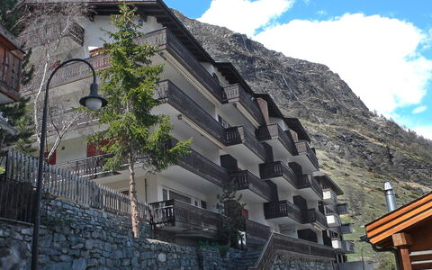 Milihaus a: Wall, Building, Town, Architecture, House, Mountain, Neighbourhood, Sky, Tree, Tourism