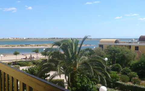 Gruissan Plage: Sky, Water, Cloud, Building, Property, Plant, Azure, Seaside Resort, Tree, Arecales