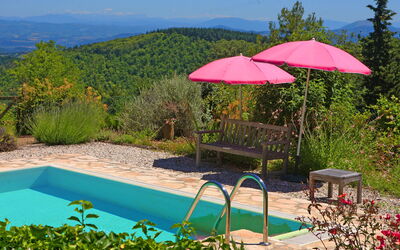 Under the umbrella , near the pool, the view behind you...a book in your hand..